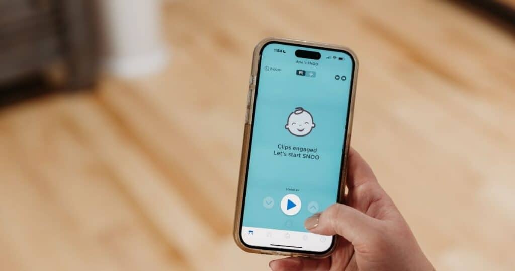 Parent holds phone up with Ssnoo app open