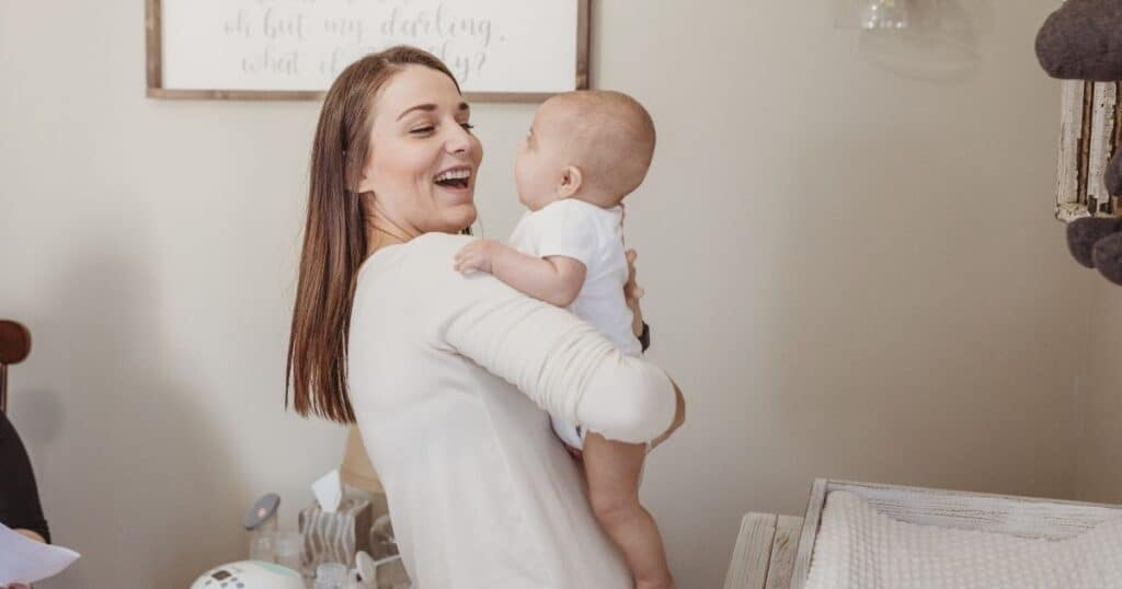 Mom and baby smile at eachother in nursery