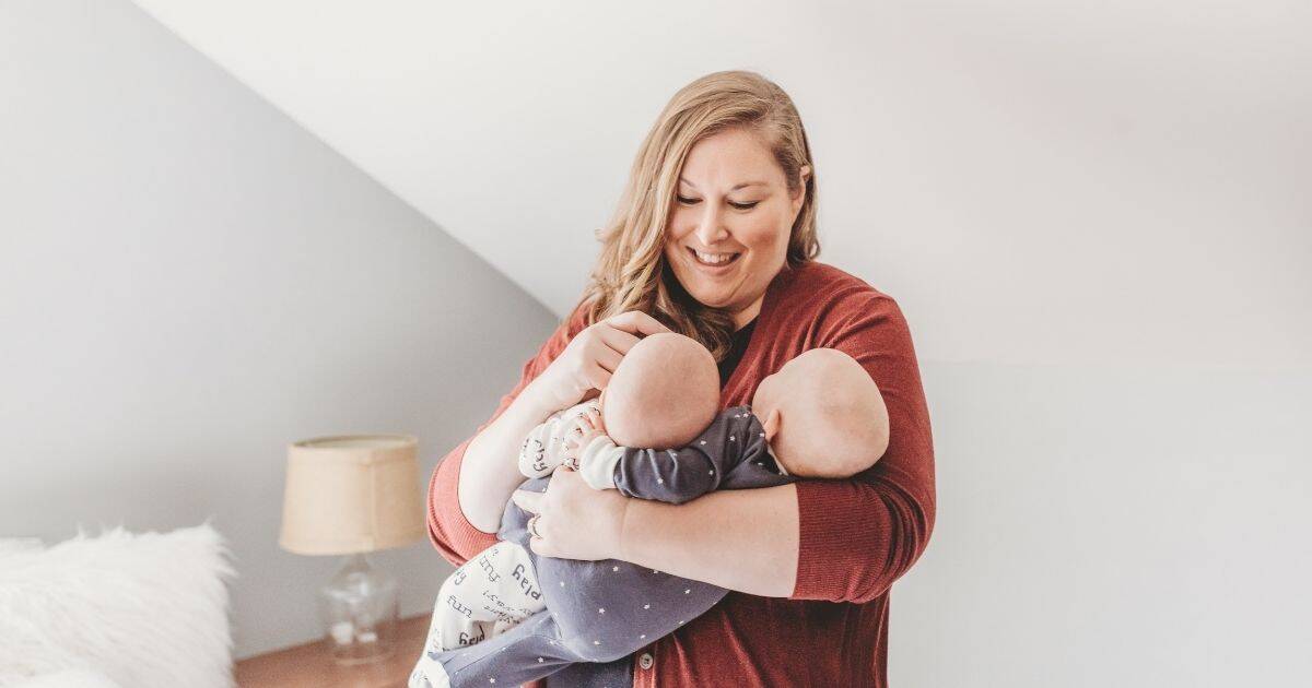 Postpartum Doula holds twins in her arms