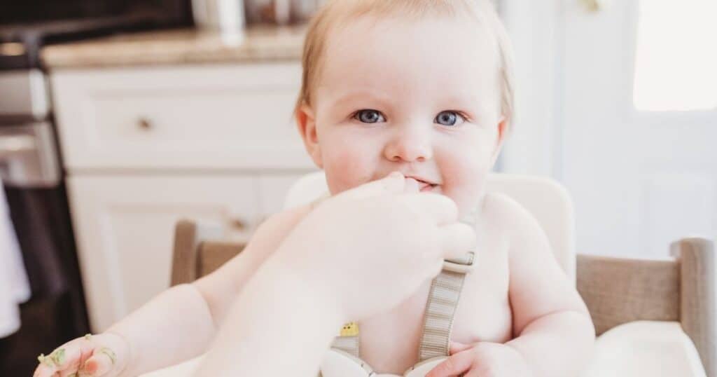 Parent-spoons-feeds-baby-solids