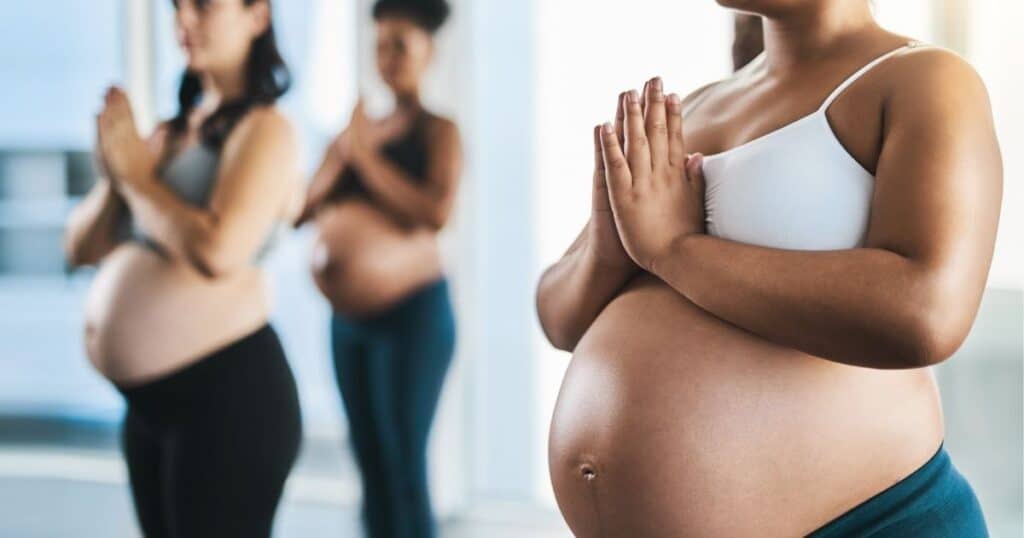 Pregnant women stand in a workout class