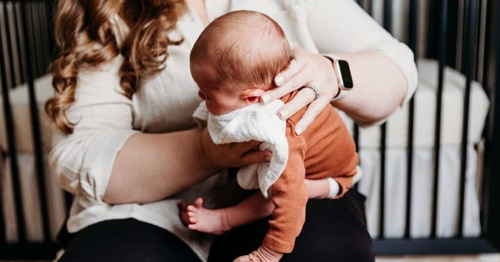 Doula burps baby on lap