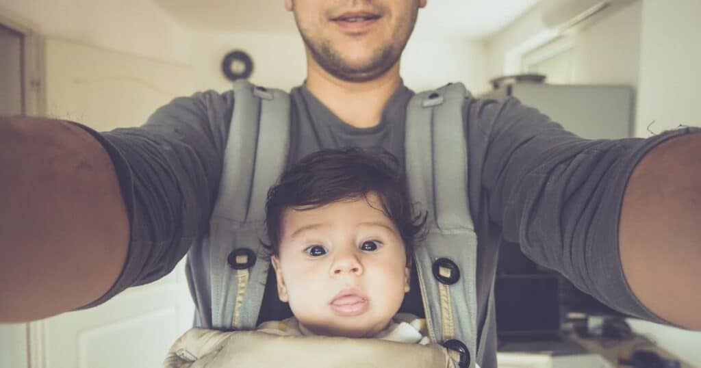 Dad hold baby front facing in carrier