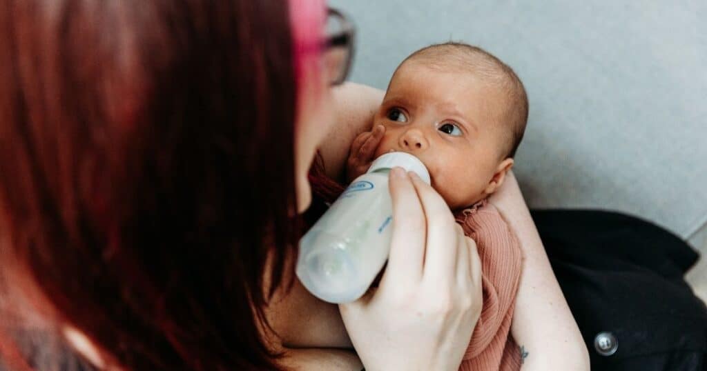Mother feeds baby from bottle