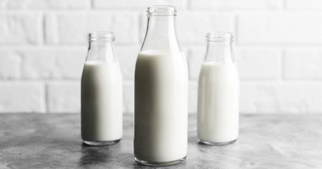 Three glass jars containing milk on a kitchen counter