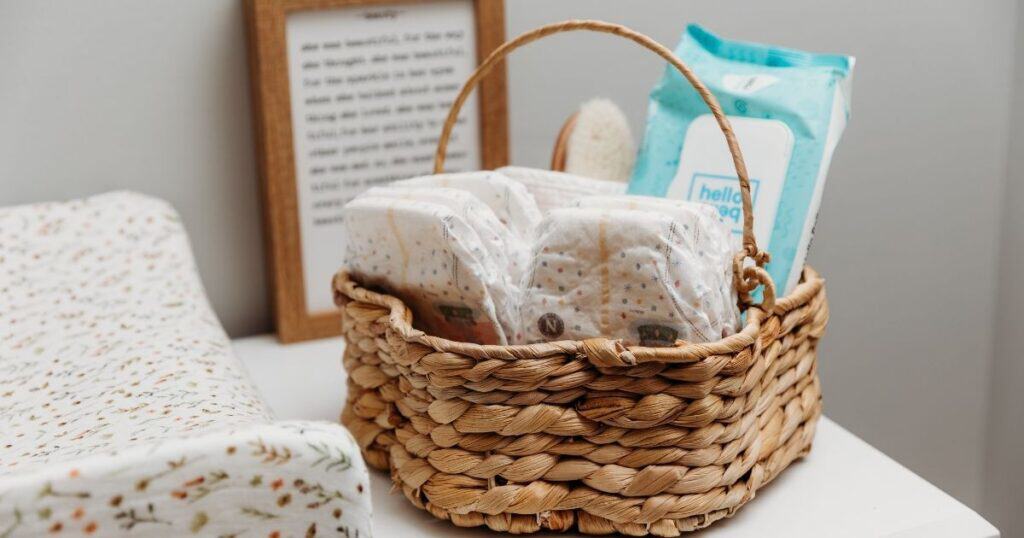 diaper changing set up with changing pad and a baasket of diapers and wipes sit on a dresser