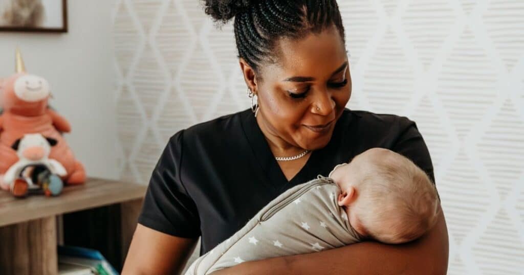 Postpartum doula holding baby