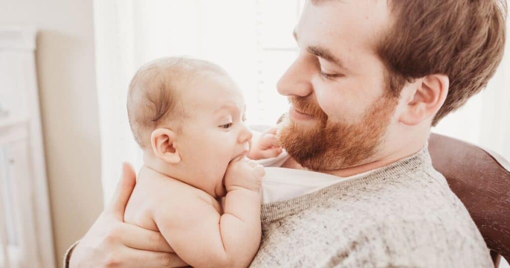 Dad smiles down at baby on his chest