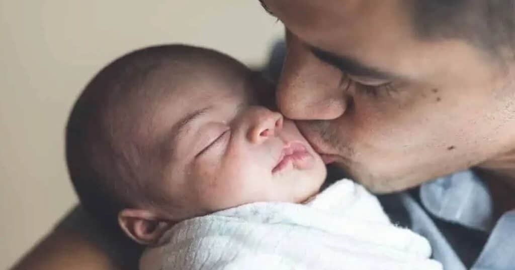 father kissing baby