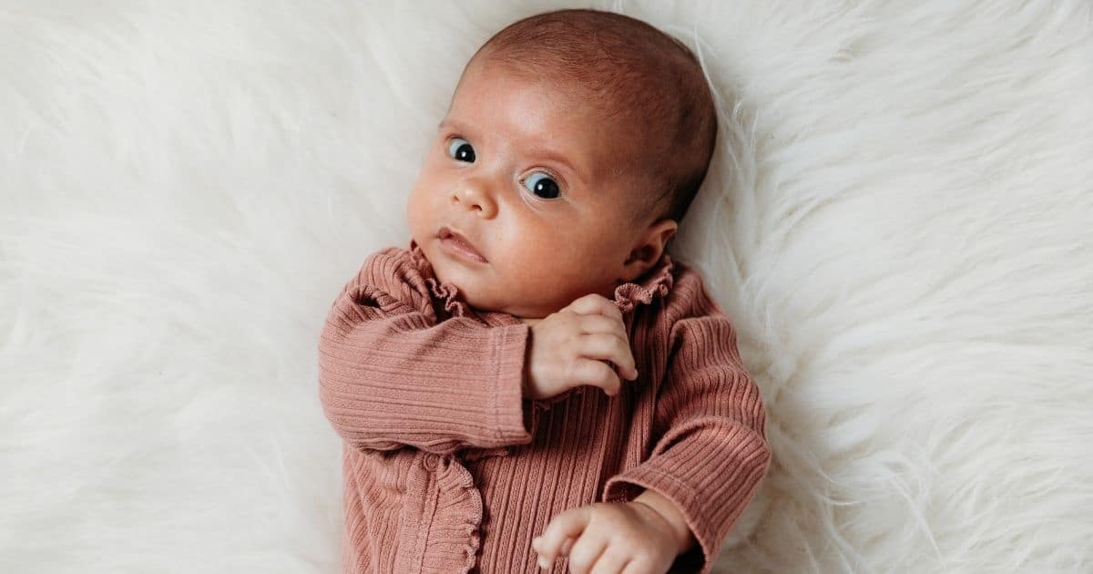 Baby looks skeptically into camera with eyebrow raised