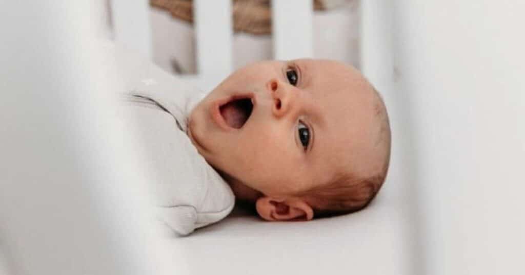 awake baby in crib with baby sleep regression