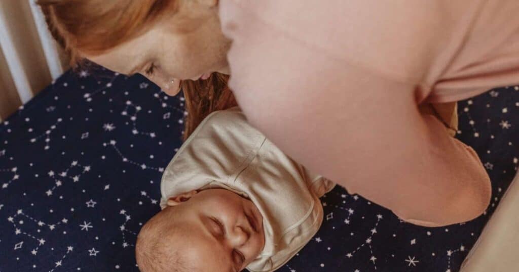 night nurse placing baby in crib