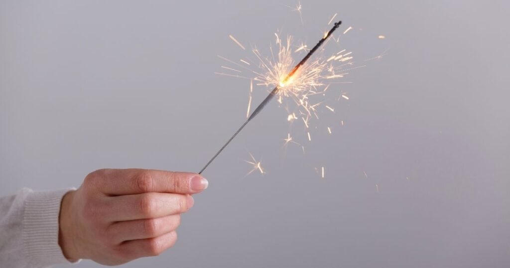 Female hand holds lit sparkler