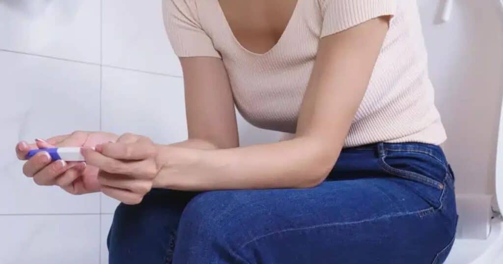 woman in first trimester of pregnancy holding pregnancy test