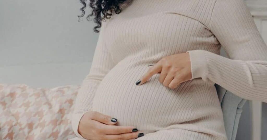 Pregnant woman pointing at belly
