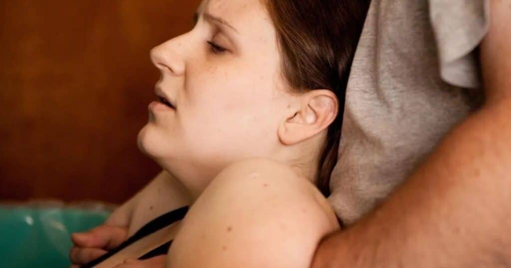 Woman in labor helped by doula.