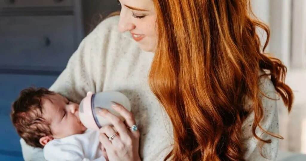 Postpartum doula bottle feeding newborn.