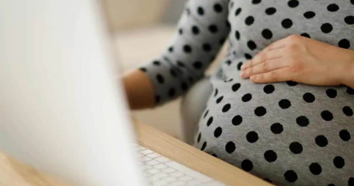 Pregnant woman sitting at computer.