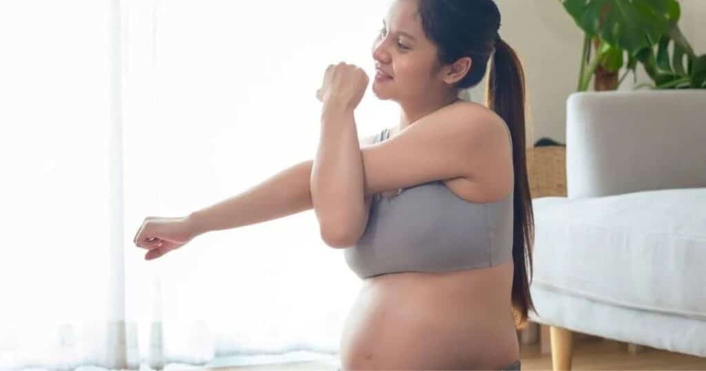 Pregnant woman doing stretches.