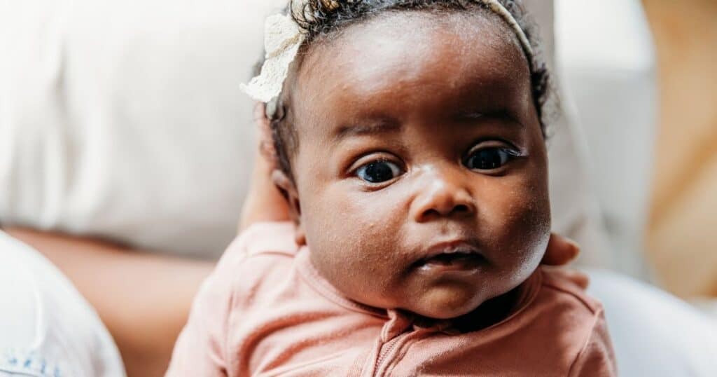 Baby stares into camera with eyebrows raised