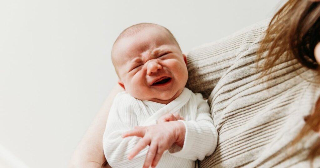Baby in woman's arms cried with discomfort