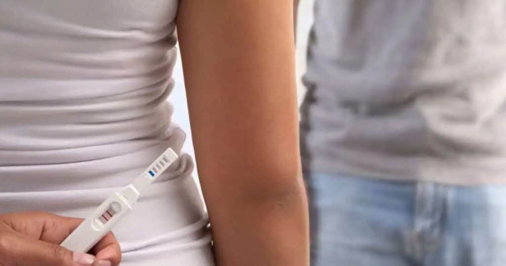 couple holding positive pregnancy test