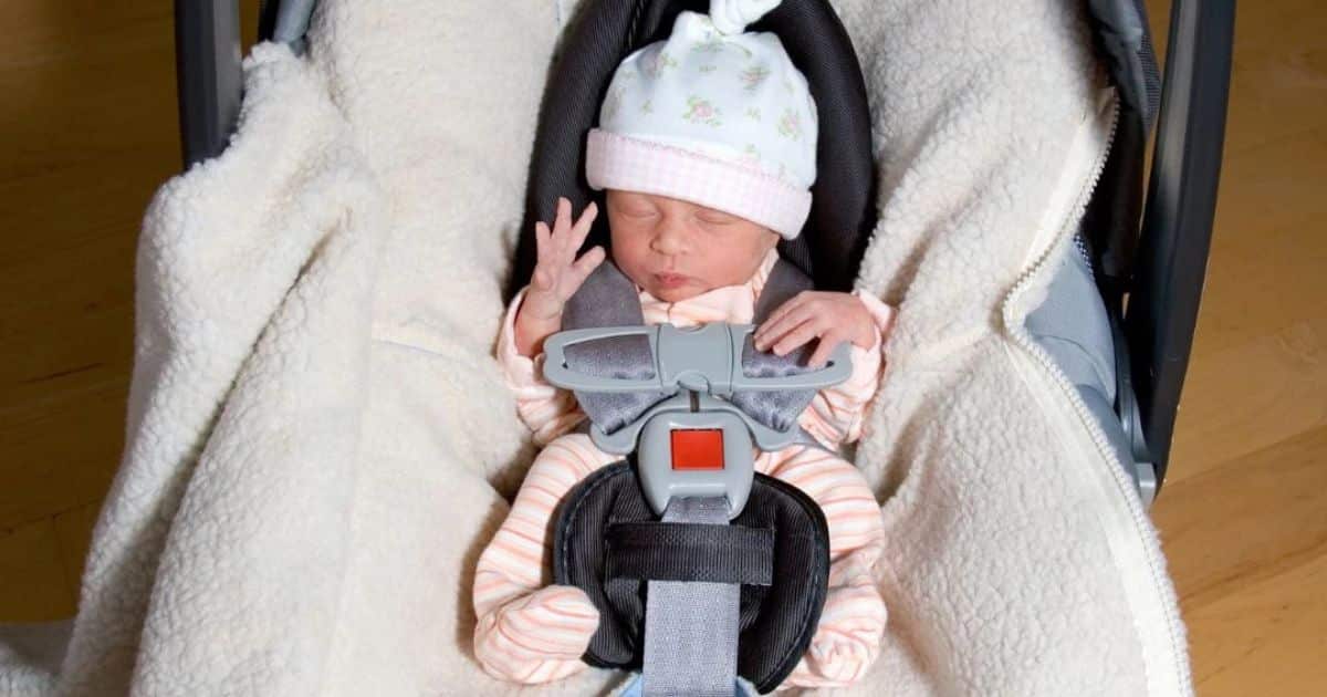 Newborn sleeping in carseat.