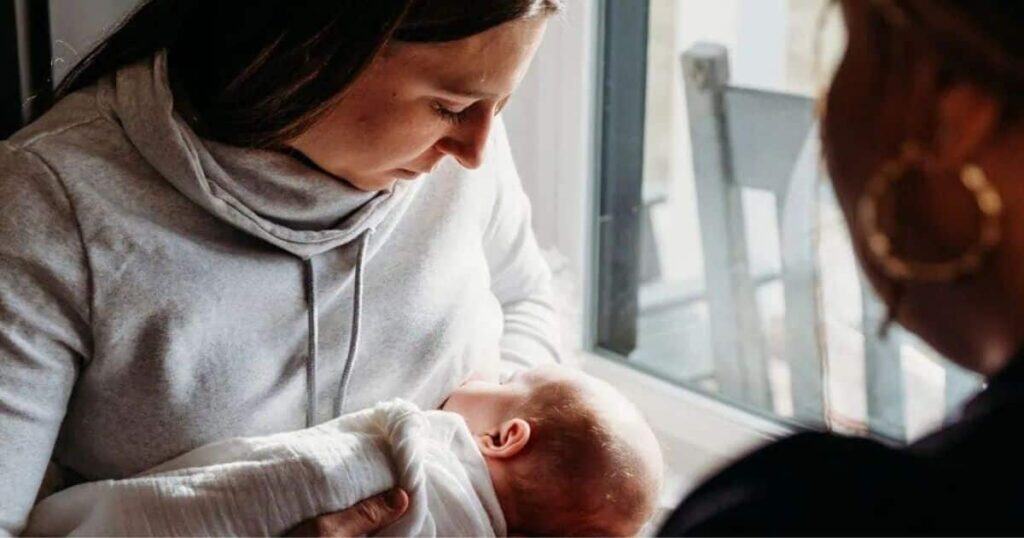 night nanny handing baby to new mom during overnight shift