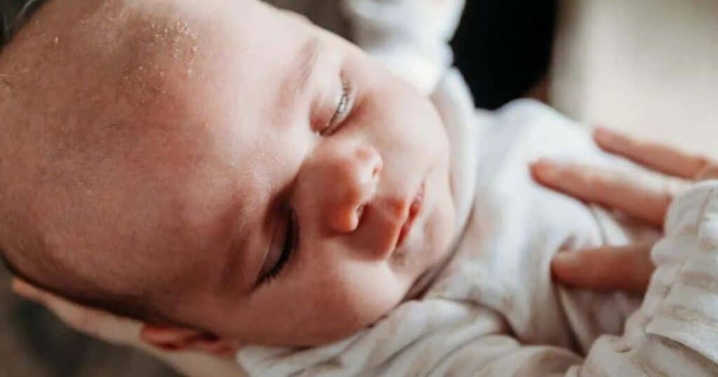 Parent caressing sleepy baby.