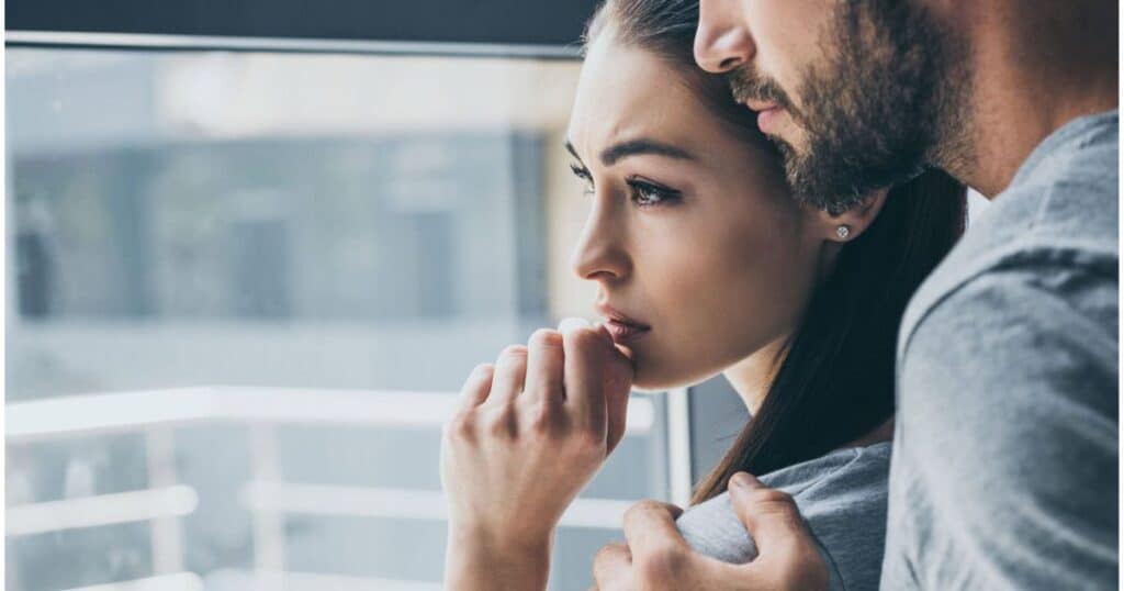 depressed couple looking out window