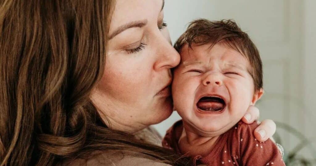 mom kissing crying baby
