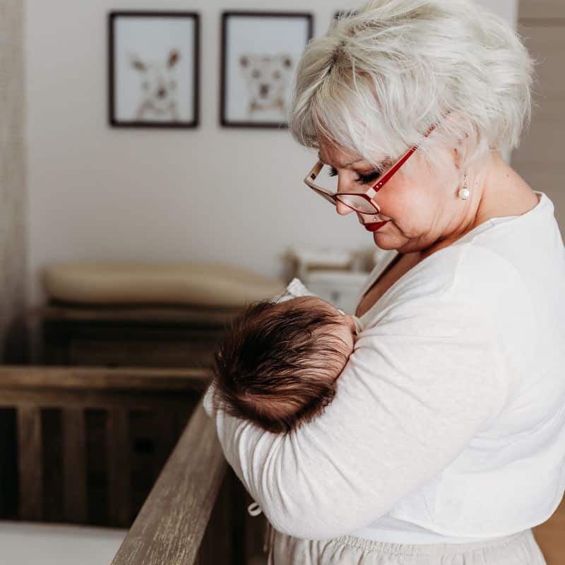 night nurse holds newborn in nursery