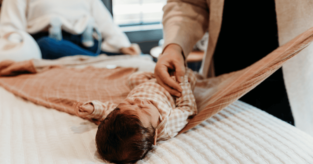 NCS swaddling a newborn while parent is pumping