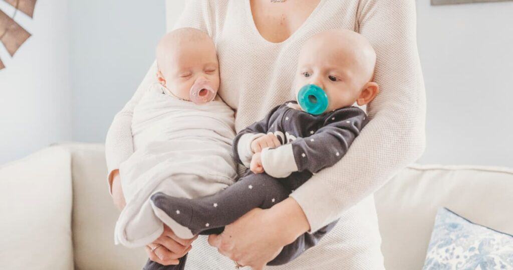Newborn Care Specialist from Well Supported Family holding twins.
