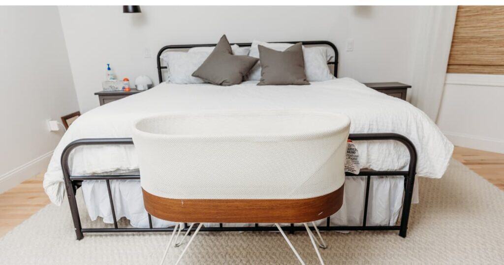 White bed with empty white bassinet