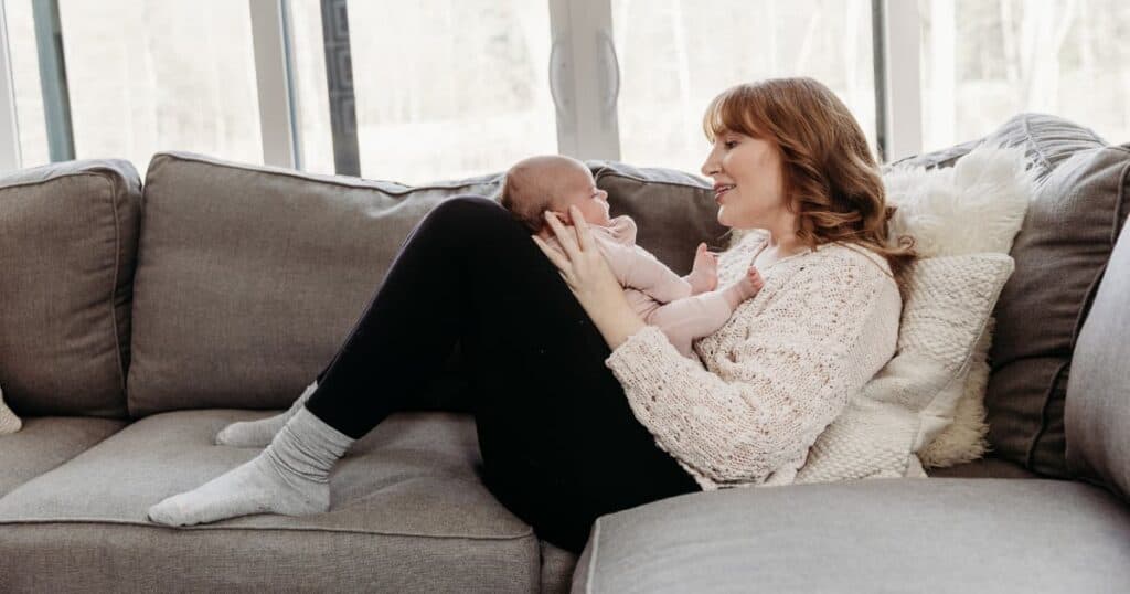 doula plays with baby on couch