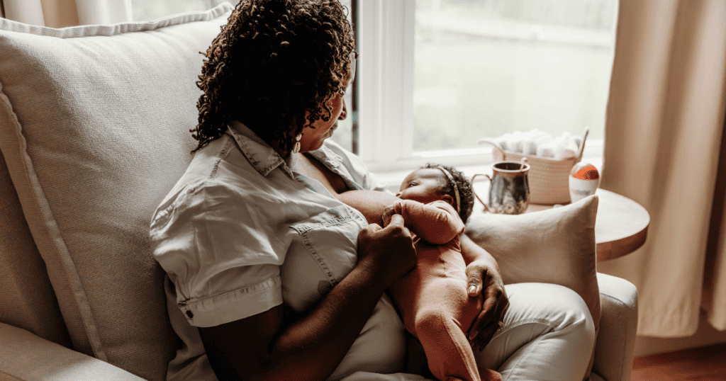 Well Supported Family client sitting in recliner learning to breastfeed a newborn baby