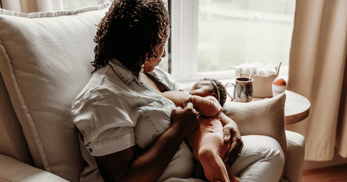 Well Supported Family client sitting in recliner learning to breastfeed a newborn baby