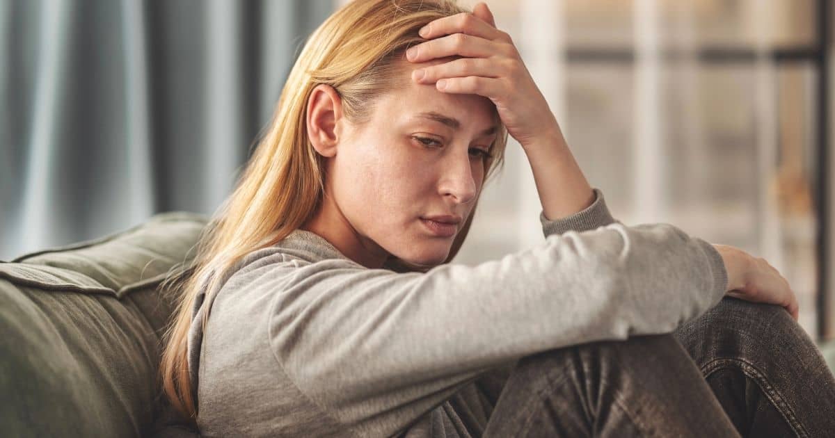 Upset mom on couch Mom with postpartum depression and anxiety