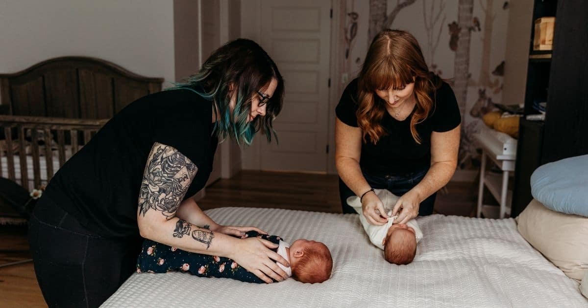Postpartum-doulas-swaddling-two-babies-on-bed Postpartum Doulas Swaddling Twins
