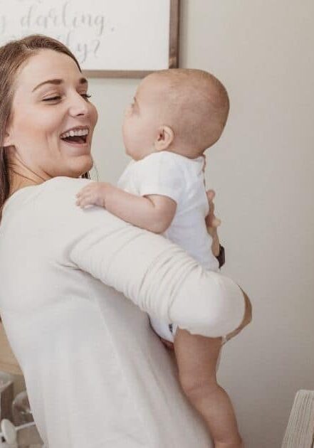 Mom and baby smile at eachother in nursery