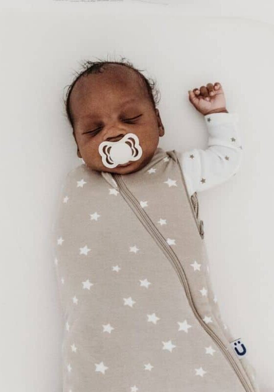 baby sleeping in swaddle on back in safe sleep position