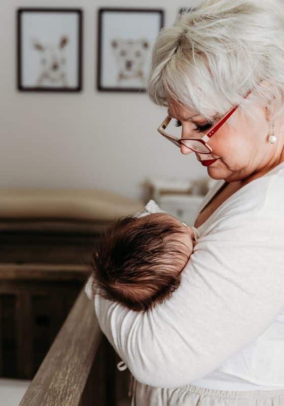 night nurse holds newborn in nursery